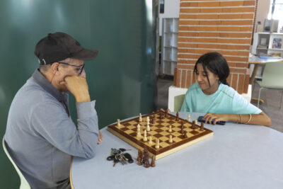 Photo d'un homme et d'une jeune fille, assis à une table en train de jouer aux échecs - Agrandir l'image 19 sur 19, fenêtre modale