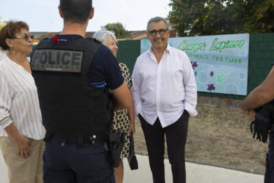 photo du Maire qui échange avec des personnes et un policier municipal de dos - Agrandir l'image 9 sur 25, fenêtre modale