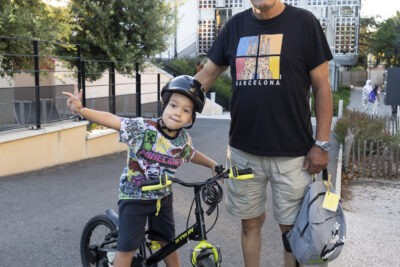 photo d'un homme et d'un enfant les bras sur le côté, arrivé en vélo, qui sourient à l'objectif - Agrandir l'image 12 sur 25, fenêtre modale