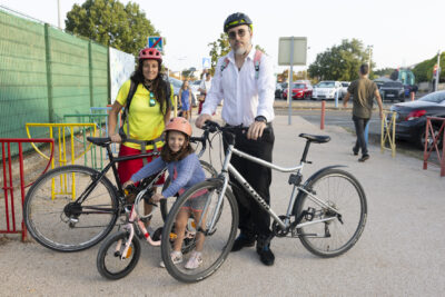 photo d'un homme et d'une femme et d'un enfant, les trois à vélo, qui posent pour la photo devant l'école - Agrandir l'image 4 sur 25, fenêtre modale