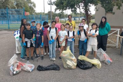 photo d'une vingtaine de personnes avec adultes et enfants réunis, en ligne, face à l'objectif avec devant eux les déchets en poubelles - Agrandir l'image 2 sur 9, fenêtre modale