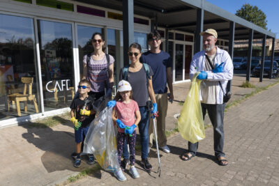 photo de 6 personnes rassemblées avec sacs poubelles et pinces pour ramasser les déchets, devant un bâtiment plat - Agrandir l'image 5 sur 9, fenêtre modale