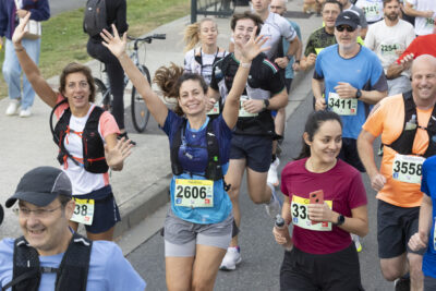 photo des coureurs sur la route, deux femmes font signe à l'objectif en souriant et les bras en l'air - Agrandir l'image 7 sur 19, fenêtre modale
