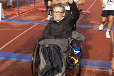 photo sur la ligne d'arrivée, un homme derrière une femme en fauteuil roulant avec une mini roue à l'avant - Agrandir l'image 10 sur 19, fenêtre modale