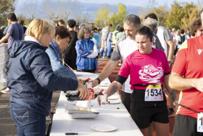photo de bénévoles qui servent du coca à des coureurs à la fin de la course - Agrandir l'image 11 sur 19, fenêtre modale