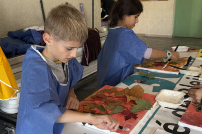 photo de deux enfants autour d'une table en train de coller des feuilles d'automne sur des cadre peints aux couleurs d'automne - Agrandir l'image 9 sur 18, fenêtre modale