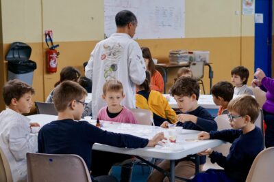 photo d'enfants concentrés à une table en train de verser quelque chose dans un petit récipient comme des petits chimistes - Agrandir l'image 13 sur 18, fenêtre modale