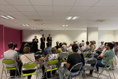 Photo d'un spectacle de jonglage par trois hommes dans une salle, une trentaine de personnes dans le public - Agrandir l'image 1 sur 5, fenêtre modale
