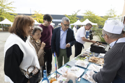 photo d'un stand, quatre élus devant regardent ce qui est présenté - Agrandir l'image 9 sur 11, fenêtre modale