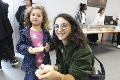 photo d'une femme agenouillée à côté d'une jeune fille, elles sourient à l'objectif, elles sont dans une salle et goûtent quelque chose - Agrandir l'image 7 sur 11, fenêtre modale