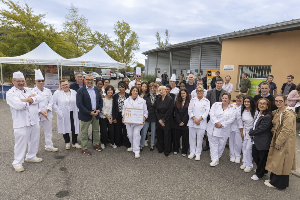 photo de groupe d'une trentaine de personnes, dont certaines en tenue de cuisiniers, qui sourient pour la photo en extérieur