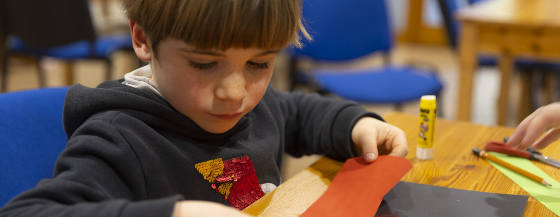 Photo d'enfant assis à table tenant du papier