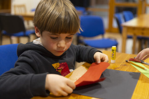 Photo d'enfant assis à table tenant du papier