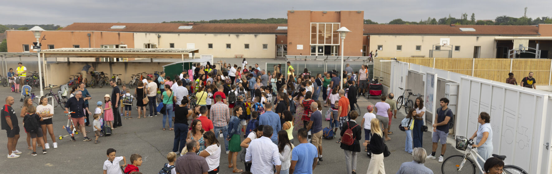 Photo d'une cour d'école avec de nombreuses familles réunies