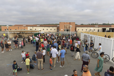 Photo d'une cour d'école avec de nombreuses familles réunies