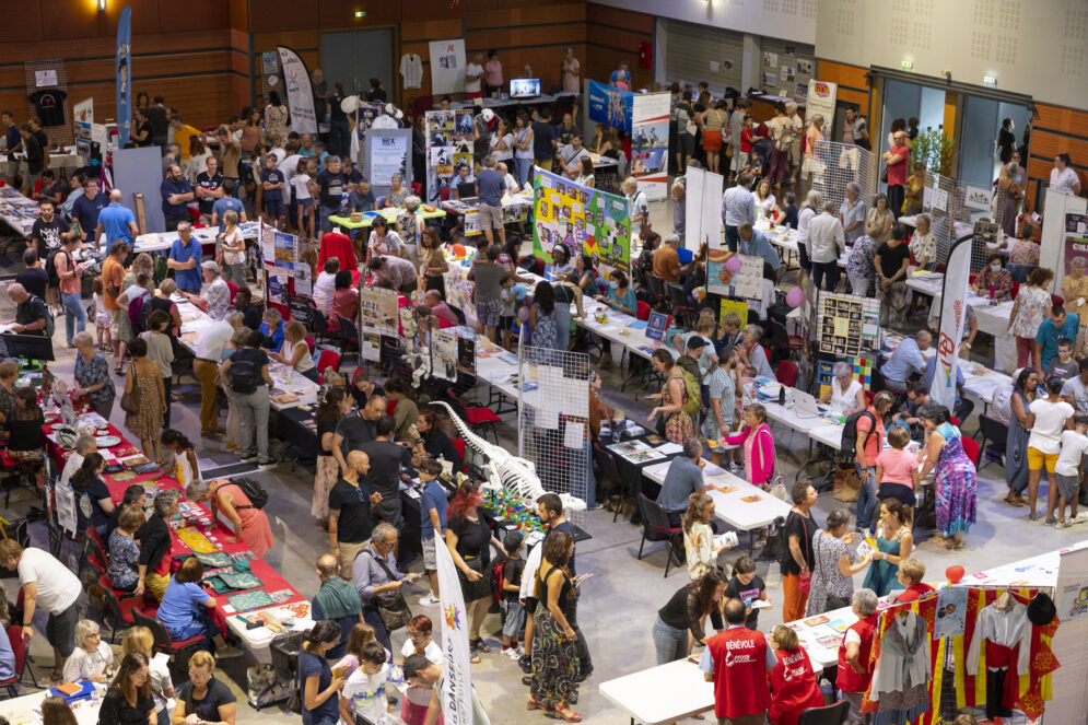 Forum des associations dans une salle, photo vue de haut avec du monde et des stands divers