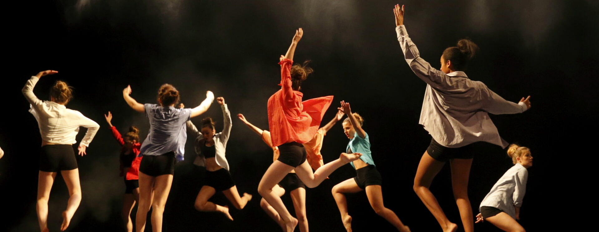 Photo d'un groupe de danseurs qui saute sur scène en même temps