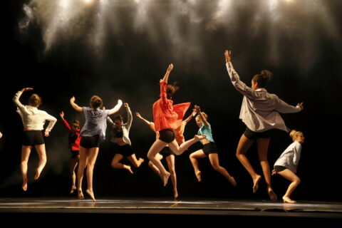 Photo d'un groupe de danseurs qui saute sur scène en même temps