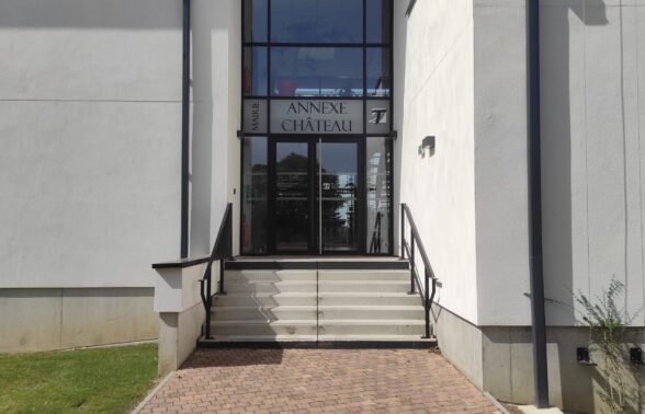 Photo de l'entrée d'un bâtiment blanc avec des escaliers, avec écrit "mairie annexe Château"