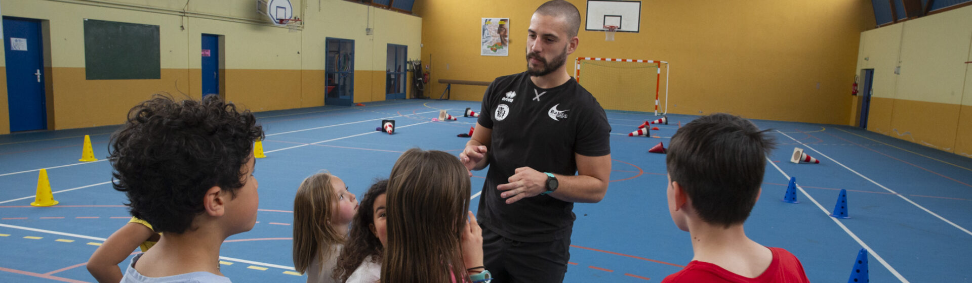 Groupe d'enfants avec un entraîneur dans un gymnase