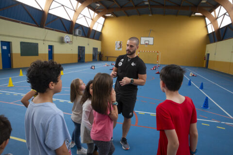 Groupe d'enfants avec un entraîneur dans un gymnase