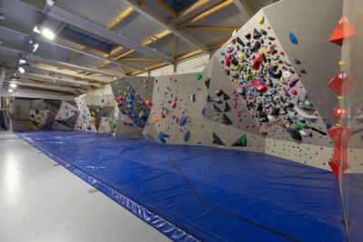 Photo du mur de bloc d'escalade avec tapis au sol, vue d'angle droite - Agrandir l'image 2 sur 3, fenêtre modale