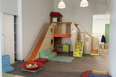Photo d'une pièce de la crèche éclairée, avec du mobilier pour les enfants, un grand toboggan - Agrandir l'image 1 sur 3, fenêtre modale