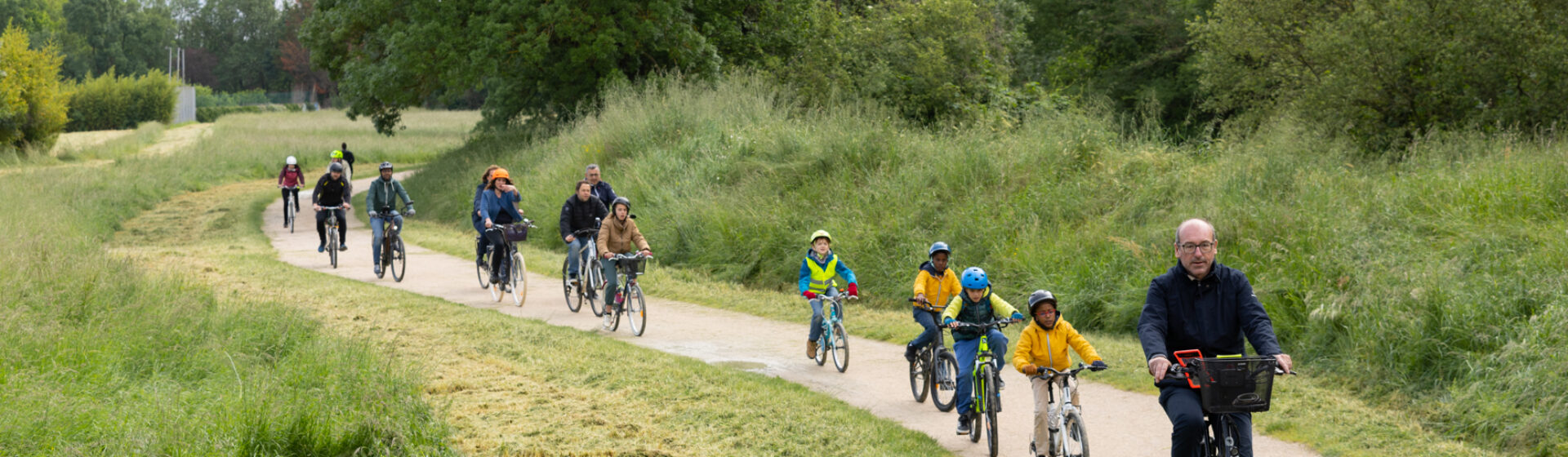 Groupe de personnes avec enfants à vélo sur un chemin cyclable