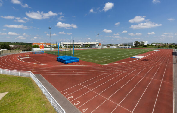 Photo de la piste d'athlétisme depuis un côté extérieur, ciel bleu