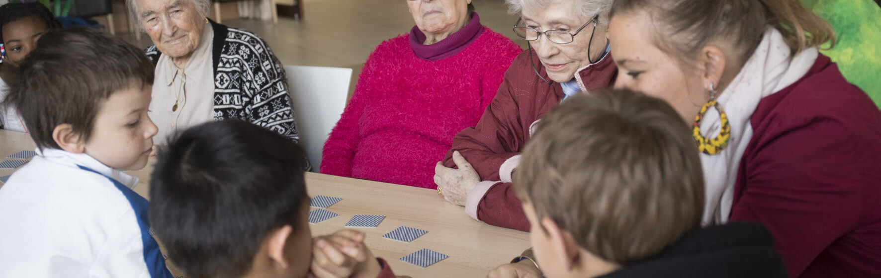 Groupe de personnes âgées et enfants autour d'un jeu