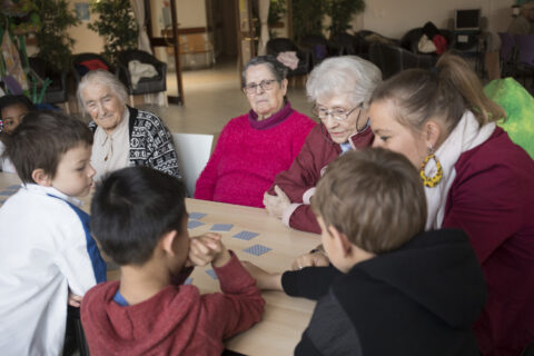 Groupe de personnes âgées et enfants autour d'un jeu