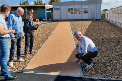 Le Maire agenouillé examine un aménagement de chemin désimperméabilisé - Agrandir l'image, fenêtre modale