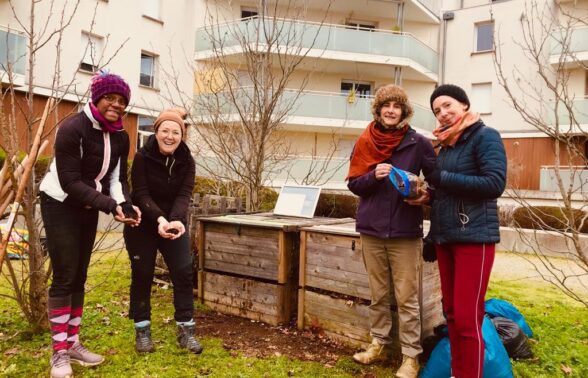 Photo de quatre femmes rassemblées autour d'un composteur
