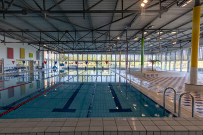 Photo d'un grand bassin de la piscine vide avec vue sur la baie vitrée au fond - Agrandir l'image, fenêtre modale