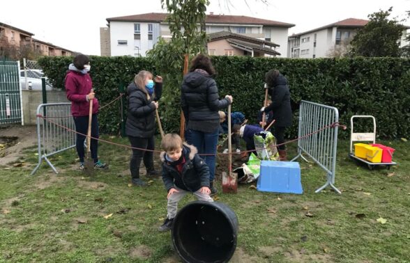 Photo de cour végétale avec des personnes équipées de pelles et rateaux