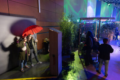 Photo de l'espace photo booth, avec deux personnes qui posent un parapluie rouge à la main - Agrandir l'image 10 sur 22, fenêtre modale