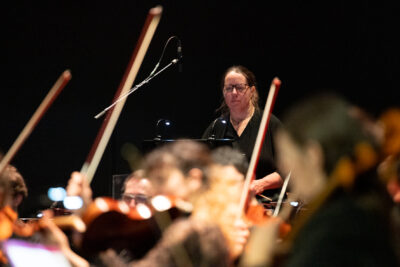 apparition de la percussionniste debout devant le parterre de musiciens floûté - Agrandir l'image 3 sur 8, fenêtre modale