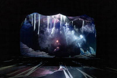 Sur cette image, apparaît toute la profondeur de la scène et un décor à la fois féérique et effrayant composé de stalagtites, de vapeurs et fumées, de lumières aveuglantes dans la nuit, avec toujours le personnage de Nozomi debout en fond de scène explorant à l'aide d'une petite lampe cet univers initiatique - Agrandir l'image 5 sur 7, fenêtre modale