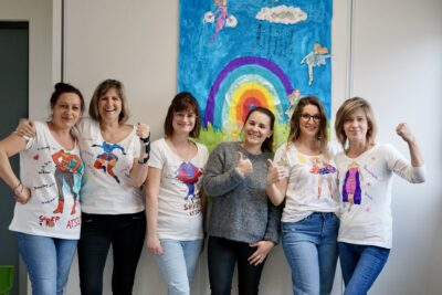 Photo de 6 femmes rassemblées avec des teeshirts sur lesquels il y a des illustrations et photomontages d'elles en super-héroïnes, elles ont le pouce en l'air ou le poing levé - Agrandir l'image 3 sur 8, fenêtre modale