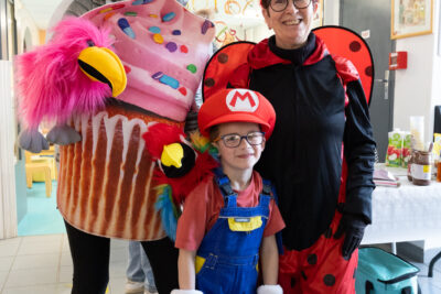 Photo de deux femmes, une déguisée en cupcake et l'autre en coccinelle, avec entre elles un petit garçons déguisé en Mario, elles sont à l'intérieur et sourient à l'objectif - Agrandir l'image 9 sur 28, fenêtre modale