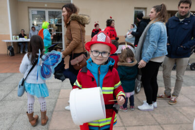 Photo d'un petit garçon déguisé en pompier qui tape sur un seau blanc en souriant à l'objectif - Agrandir l'image 4 sur 28, fenêtre modale