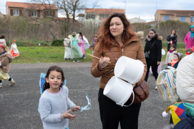 Photo d'une femme accompagnée d'une petite fille avec des ailes bleues de fée dans le dos, qui tiennent des seaux blancs avec des baguettes pour taper dessus - Agrandir l'image 28 sur 28, fenêtre modale