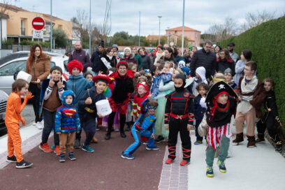 Photo du défilé de face, les enfants au premier rang posent et font des grimaces pour la photo, on a un vampire, un pompier, un super héros, un ninja, un pirate, un jedi... - Agrandir l'image, fenêtre modale