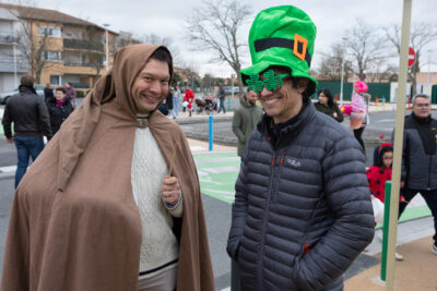 Photo de deux hommes déguisés, un avec une sorte de cape de magicien beige, et une baguette magique, et l'autre avec un chapeau irlandais et des lunettes vertes en forme de trèfle, les deux sourient à l'objectif - Agrandir l'image 12 sur 28, fenêtre modale