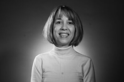 Photo d'une femme avec une coupe au carré, un haut clair, qui pose assise face à l'objectif et sourit - Agrandir l'image 5 sur 21, fenêtre modale