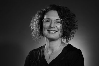 Photo portrait en noir et blanc d'une femme qui porte des lunettes, cheveux au-dessus de l'épaule - Agrandir l'image 2 sur 21, fenêtre modale