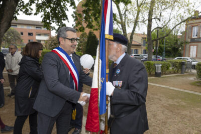 Le Maire Frédéric Parre serre la main à un porteur de drapeau en uniforme de militaire - Agrandir l'image 6 sur 10, fenêtre modale