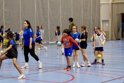 Photo d'un enfant qui tient le ballon de handball et marche vers l'avant, il y a d'autres enfants derrière lui - Agrandir l'image 9 sur 14, fenêtre modale