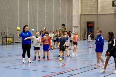 Photo d'un entraînement de handball avec des enfants qui font la queue avec un ballon - Agrandir l'image 8 sur 14, fenêtre modale