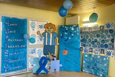 Photo d'un décor illustré en bleu avec un ruban bleu, une pièce de puzzle bleue, des ballons - Agrandir l'image 3 sur 14, fenêtre modale